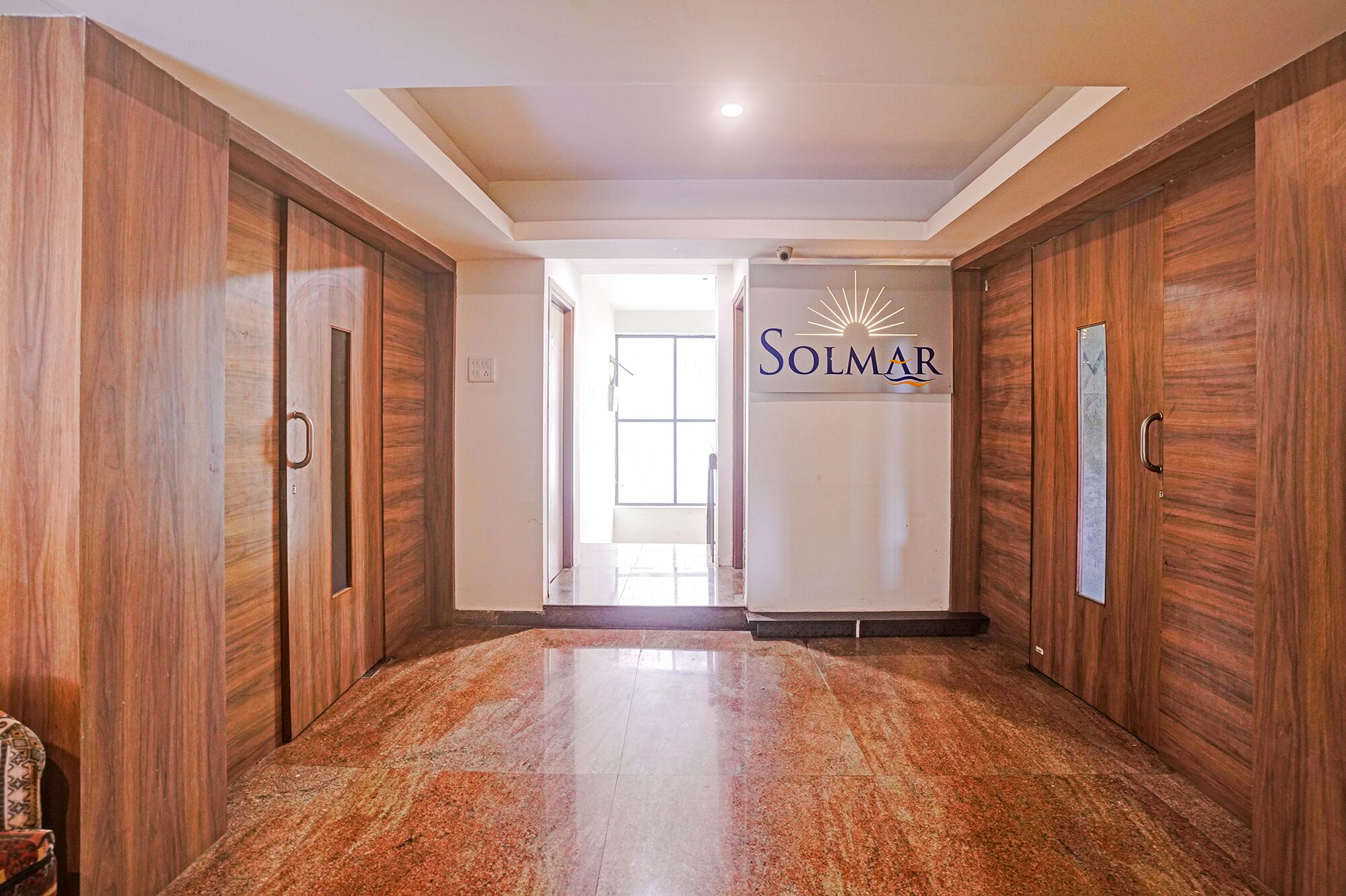 A hallway with wooden doors and a sign reading 'Solmar.'