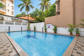 A swimming pool with a white fence, potted plants, and a sign for Hotel Solmar. - Oriva Solmar (Panaji)