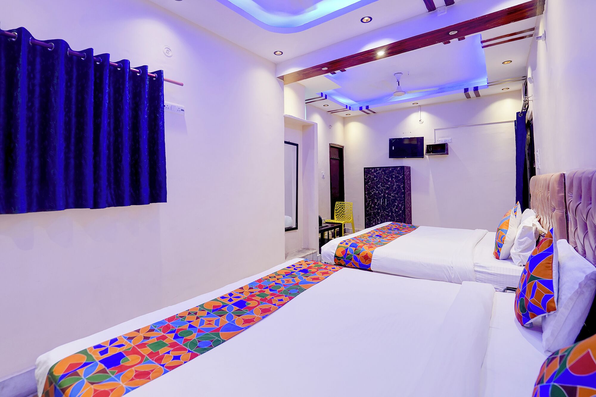 A hotel room with two beds, a bathroom, and a shower area.