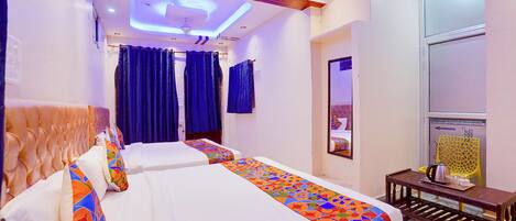 Habitación de hotel de diseño moderno, con una cama grande y ropa de cama colorida, un techo con iluminación empotrada y un espejo grande en la pared.