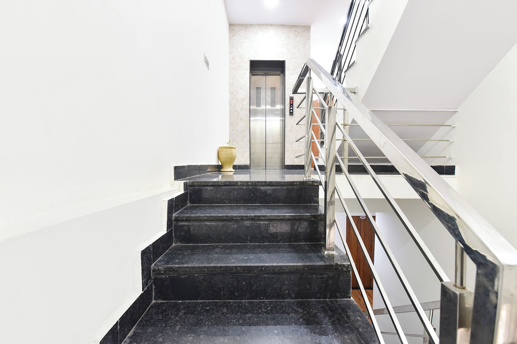 Una escalera con barandilla que lleva a un ascensor.