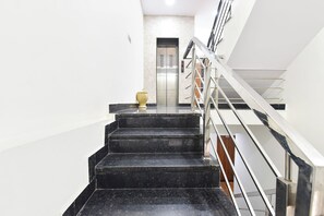 Eine Treppe mit Handlauf, die zu einem Aufzug führt.