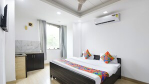 A bedroom with a bed, a window, an air conditioning unit, and a ceiling fan. - Via Signature Villa (New Delhi)
