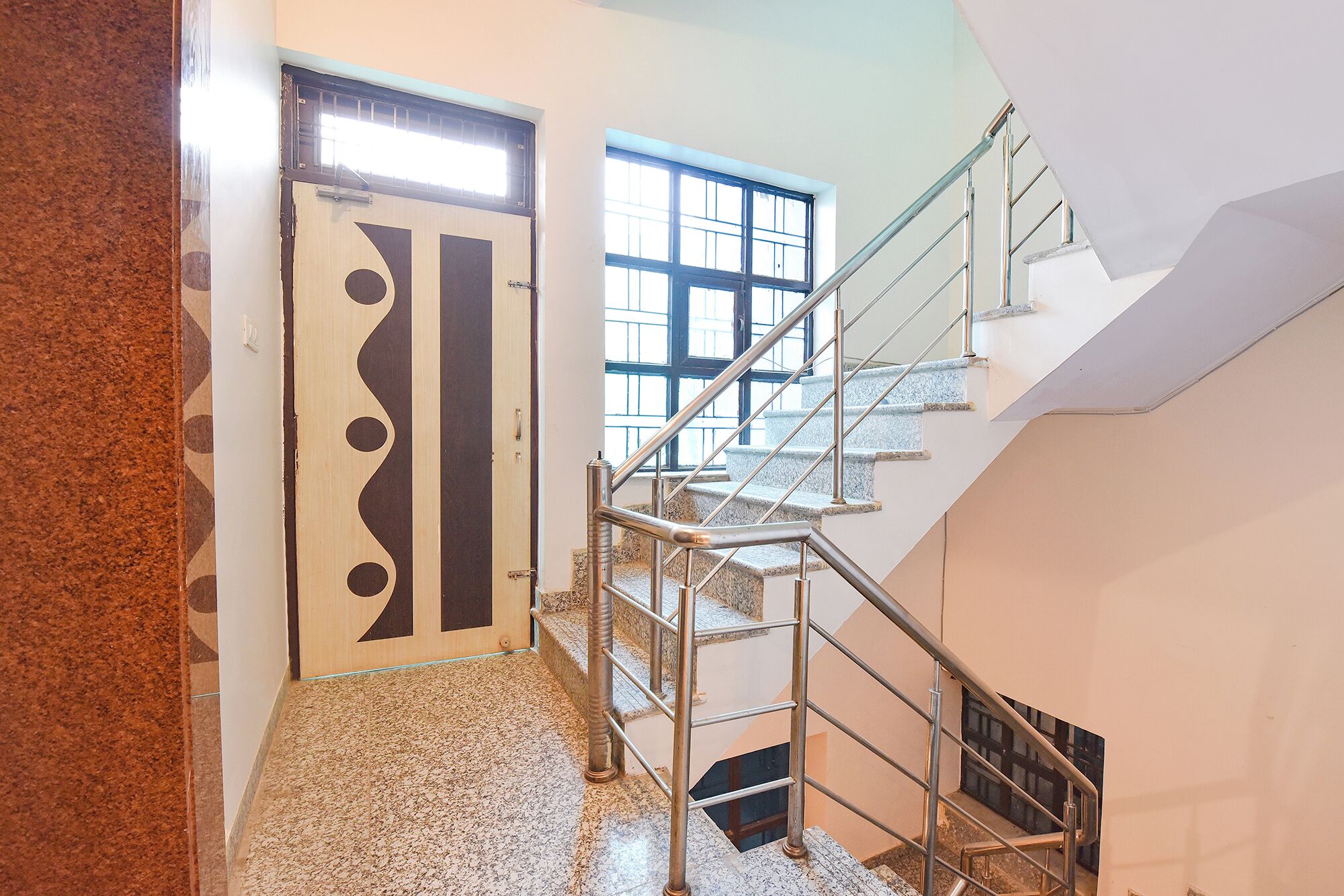 A staircase with metal railings and a patterned door.