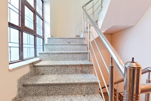 A staircase with metal railings and granite steps leading to a landing. - Fabhotel Prime Stay Inn (Jaipur)