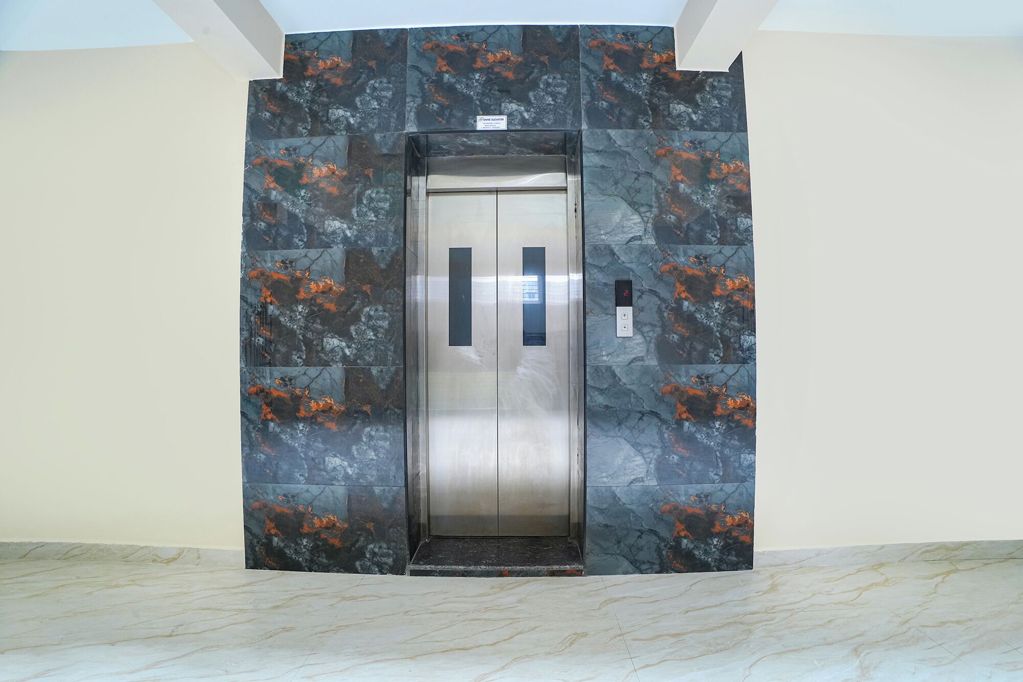 An elevator with a metallic finish and a control panel on the right side.