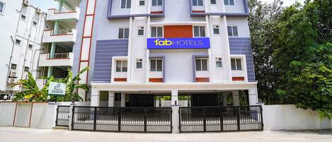 Un immeuble à plusieurs étages, sur lequel on peut lire une enseigne indiquant « fabHOTELS », ce qui signifie qu’il s’agit d’un hôtel.
