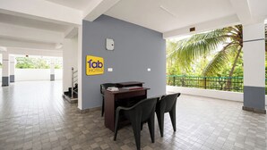 Un hall d’hôtel avec un comptoir d’accueil, des chaises et un panneau indiquant « Fab Hotels ».