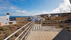A coastal property with a wooden deck, wind turbines, and modern buildings. - Casas Bioclimáticas Iter El Dispositivo (Granadilla de Abona)