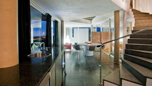 A modern interior with a kitchen area, dining space, and a staircase. - Casas Bioclimáticas Iter El Dispositivo (Granadilla de Abona)