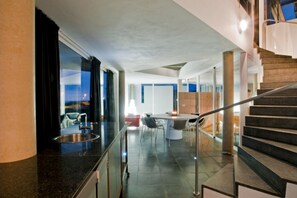 A modern interior with a kitchen area, dining space, and a staircase. - Casas Bioclimáticas Iter El Dispositivo (Granadilla de Abona)