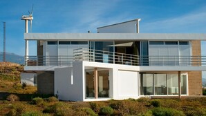 A modern two-story building with large windows and a balcony. - Casas Bioclimáticas Iter El Dispositivo (Granadilla de Abona)