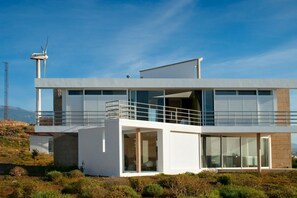 A modern two-story building with large windows and a balcony. - Casas Bioclimáticas Iter El Dispositivo (Granadilla de Abona)