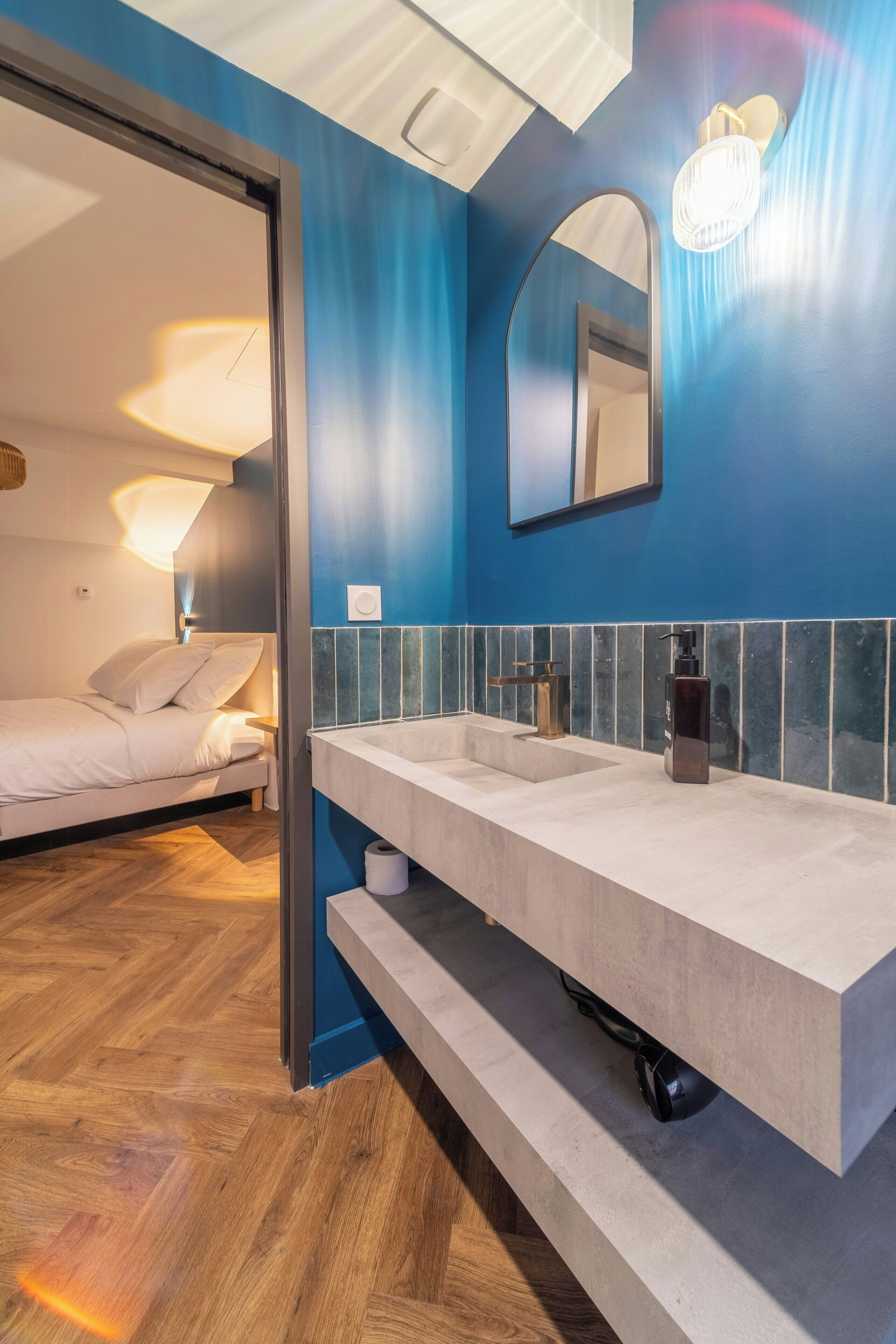 A modern bathroom with a dual sink vanity, a mirror, and a wooden floor.