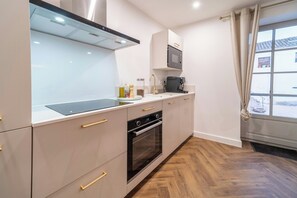 Eine moderne Küche mit Backofen, Kaffeemaschine und einem Fenster mit Blick ins Freie.