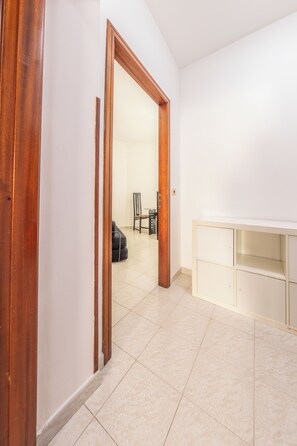 A hallway with a wooden door frame, a tiled floor, and a white wall. - Andrè Casa Vacanza (Lioni)