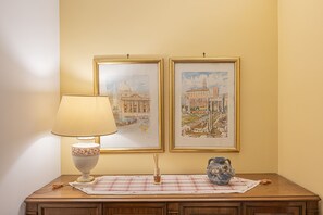 A table with a lamp, a vase, and two framed artworks. - 4BNB - Domus Battistini (Rome)
