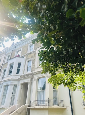 A multi-story building with a white facade and a balcony with a black railing. - Luxury flat in Notting Hill, 4 mins Portobello Market. 3 large double beds. (London)