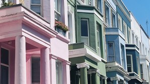 Fileira de casas coloridas em estilo arquitetônico variado, com sacadas.