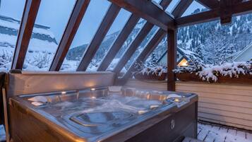 Uma banheira de hidromassagem com vista para montanhas cobertas de neve.