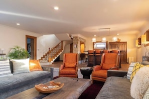 A spacious living area with a fireplace, a staircase, and a dining area with chairs. - Quinta Esmeralda - "Main House" Countryside Farm Stay Near Porto & Douro (Mosteiró)