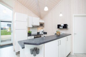 Eine moderne Küche mit weißen Schränken, einer schwarzen Arbeitsplatte und einem eingebauten Backofen.