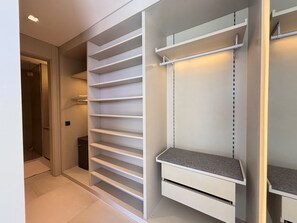 Ein begehbarer Kleiderschrank mit mehreren Regalen und einer Kleiderstange.