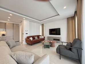 Ein modernes Wohnzimmer mit einer Couch, einem Sessel und einem Couchtisch.
