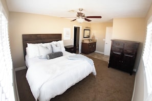 A bedroom with a bed, a dresser, a vanity, and a ceiling fan. - Game Room, Near Lake & Launch Ramp -Sleeps 8 (Lake Havasu City)