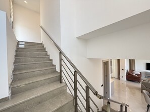 A staircase with a metal railing leading to a second-floor landing.