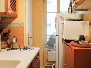 Eine Küche mit Herd, Kühlschrank und verschiedenen Küchenutensilien.