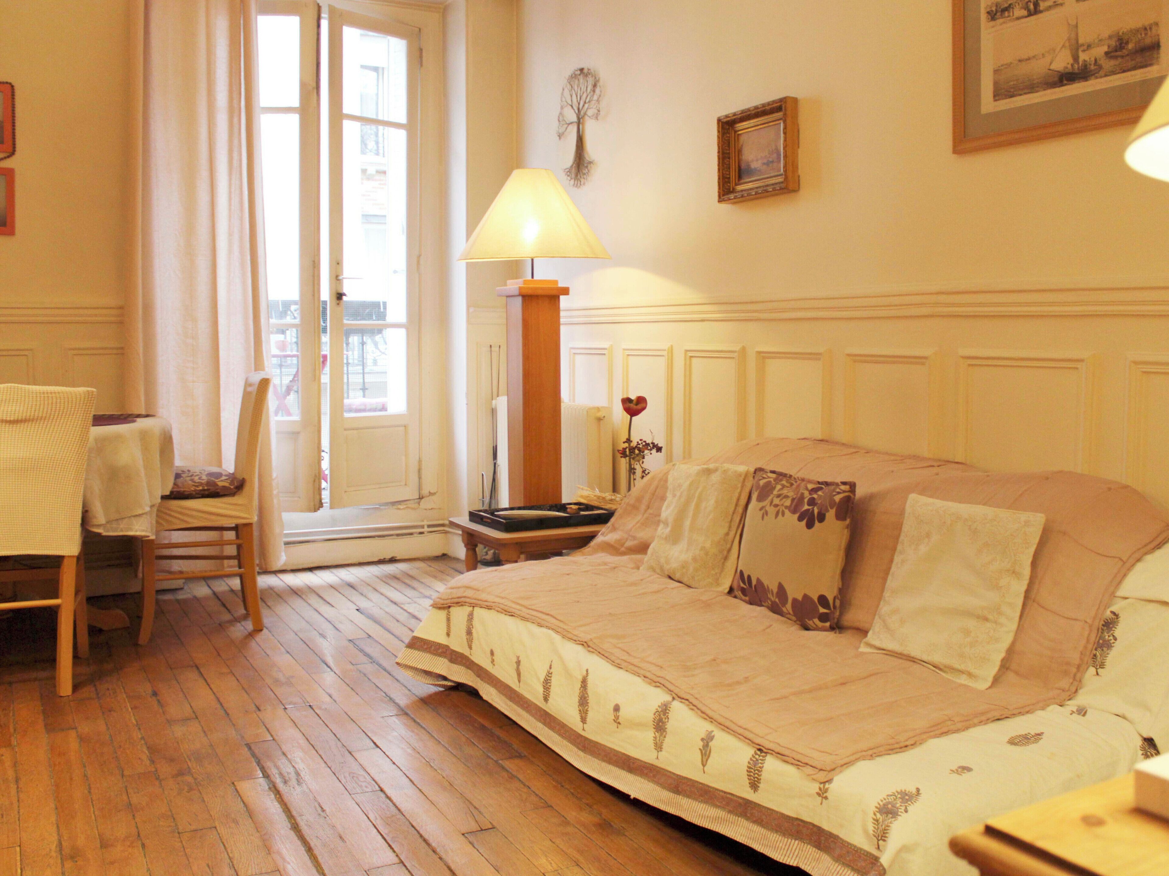 Una habitación con cama, una silla, una lámpara y una puerta.