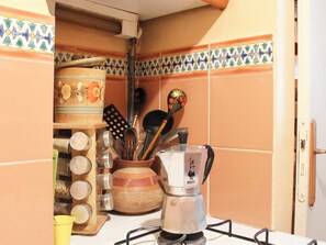 Eine Küche mit Gasherd, Kaffeemaschine und verschiedenen Kochutensilien.