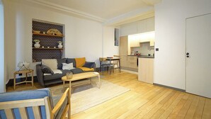 A compact living space with a sofa, coffee table, and a small dining area. - Charming Well Purified Studio Near Sacre Coeur (Paris)