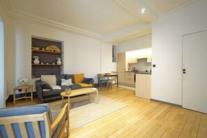 A compact living space with a sofa, coffee table, and a small dining area. - Charming Well Purified Studio Near Sacre Coeur (Paris)