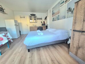 Ein gemütlicher Raum mit Bett, einer kleinen Küchenzeile und einem Essbereich.