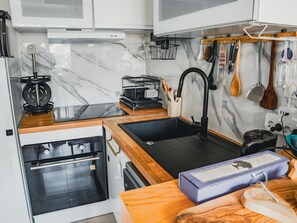 A modern kitchen with a built-in oven, a black sink, and wooden countertops. - 34 m² apartment with balcony in Montpellier (Montpellier)