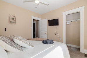 A bedroom with a bed, a television mounted on the wall, and a closet. - Walk Lakewood - Game Room - King Bed - Sleeps 10 (Lakewood)