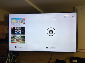 A television screen displaying a video game interface with options to select games and continue. - Walk Lakewood - Game Room - King Bed - Sleeps 10 (Lakewood)