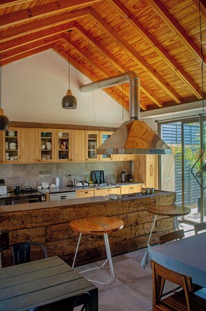 A modern kitchen with wooden cabinets, a central island, and a large window.