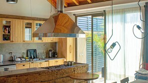 Une cuisine avec des meubles de rangement en bois, une cuisinière encastrée et un coin repas comprenant une table et des chaises.