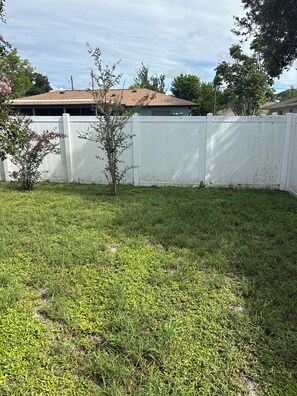 A fenced backyard with a grassy area and a small tree. - Great house in Sarasota close to Gulf beaches, golf courses downtown and UTC (Sarasota)