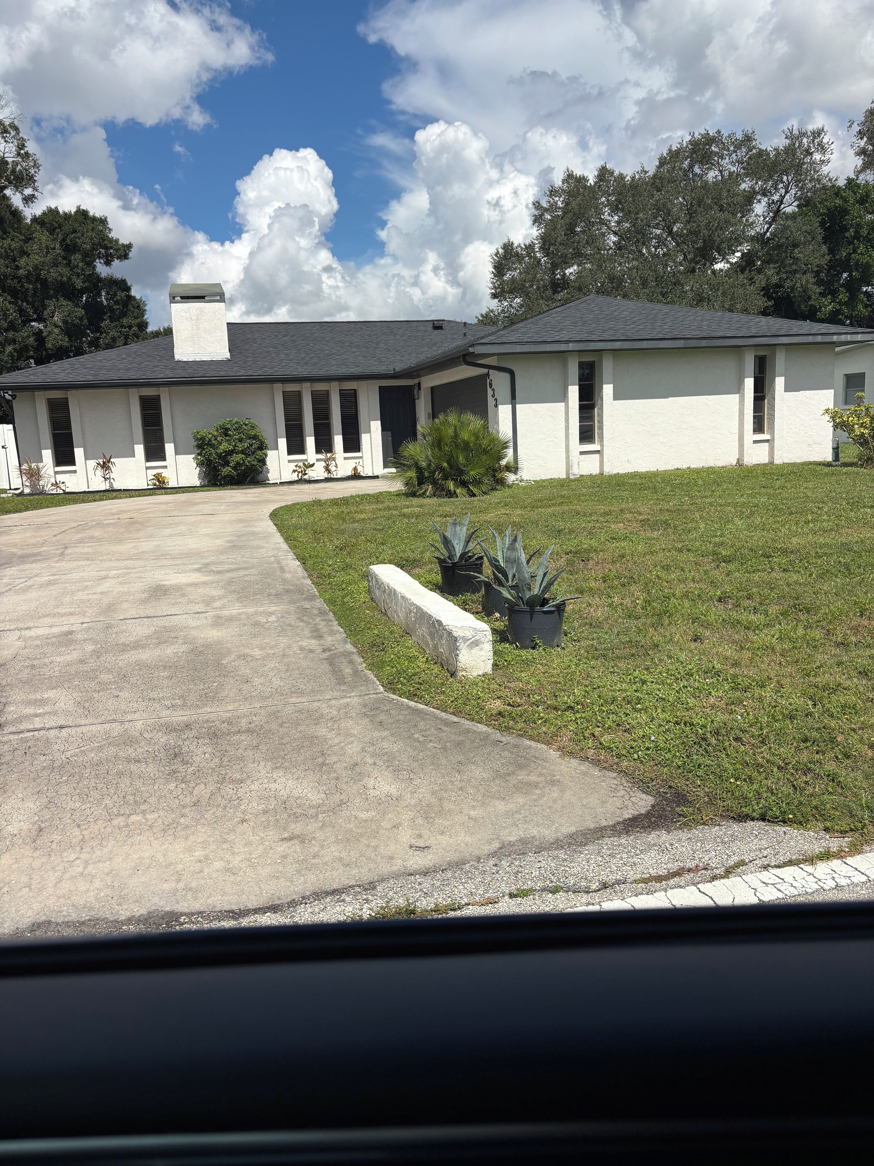 A two-story house with a driveway leading to a garage.
