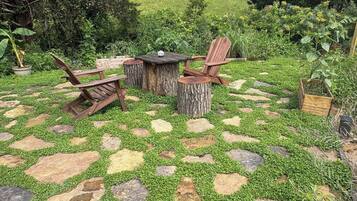 Un espace extérieur aménagé avec une table et des chaises, entouré d’un sol en pierre et en gazon formant un motif décoratif.