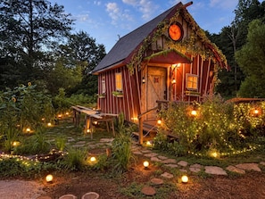 A rustic cabin with a wooden exterior, a porch, and a staircase leading to the entrance. - The Crooked Cabin - Wood-Fired Hot Tub near RRG (Lee County)