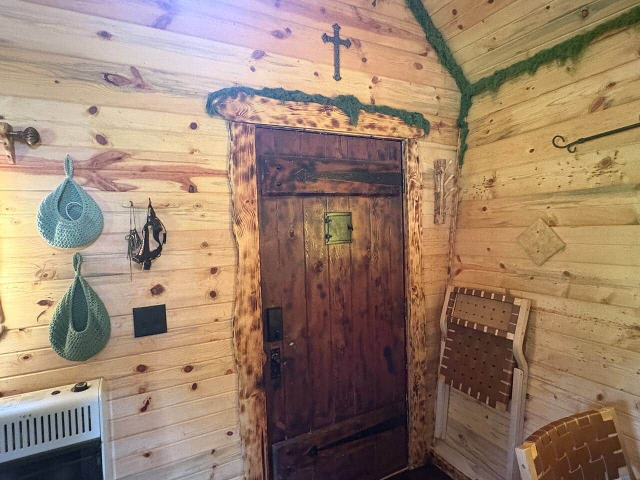 Ein Holzinterieur mit einer Tür, einem Heizkörper und einem an der Wand befestigten Haken.