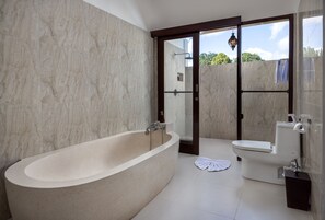 Ein Badezimmer mit freistehender Badewanne, Toilette und einer Duschkabine.