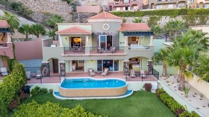 Un edifici residencial de diversos pisos amb piscina, balcons i jardí paisatjista.
