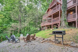 Ein rustikales Blockhaus mit einer Terrasse, umgeben von dichtem Wald.