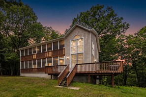 A two-story building with a balcony and a staircase leading to the upper level. - Paw Paw Mountain Lodge w/River Access & Fire Pit (Paw Paw)